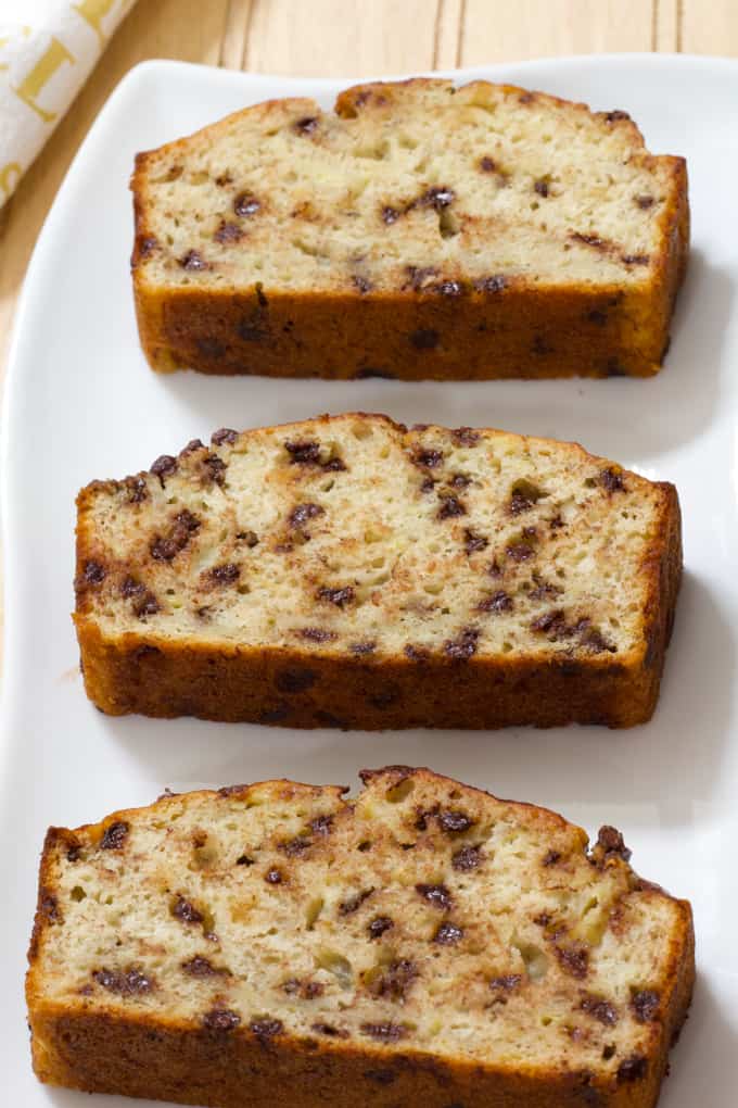 Three slices of banana bread laying flat on a white plate.