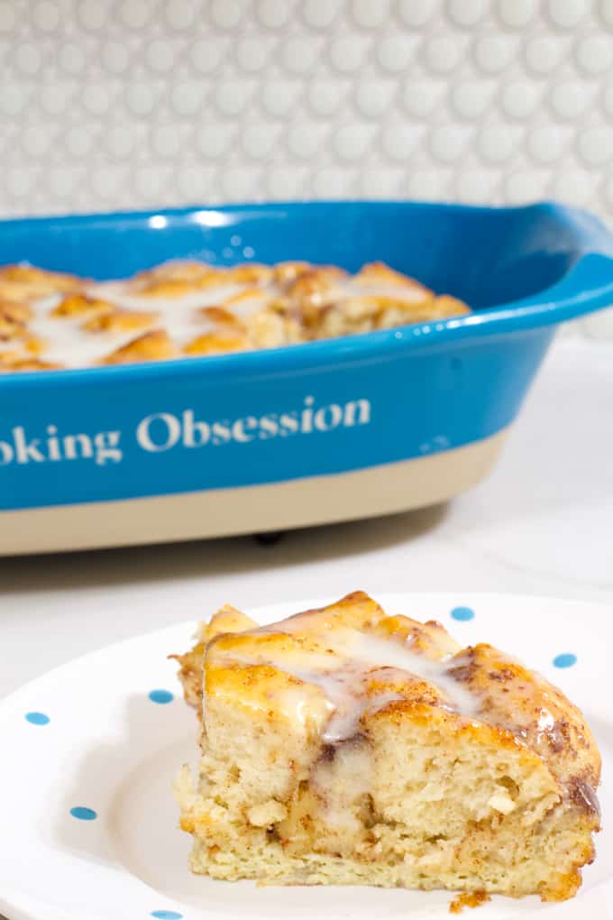 Close up of one serving on a plate in the foreground and the rest of the casserole in the background.