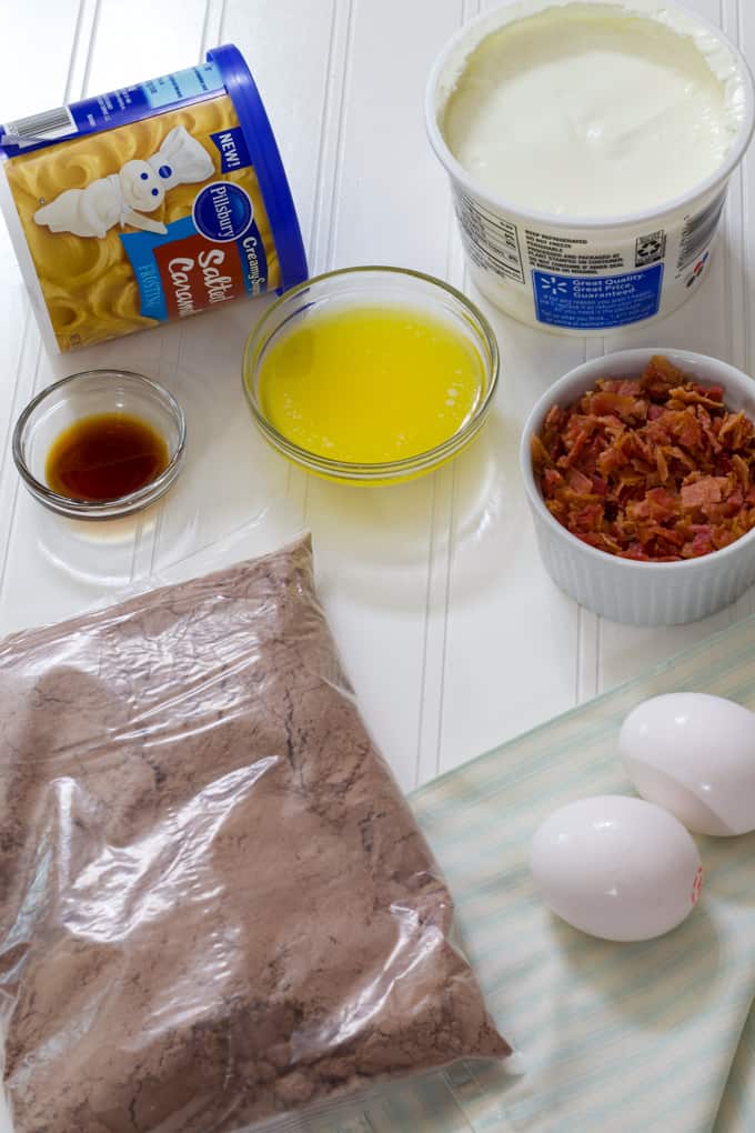 All of the ingredients needed to make chocolate cupcakes topped with caramel frosting and bacon.