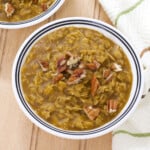 Close up view of a bowl filled with pumpkin spice oatmeal topped with chopped pecans.