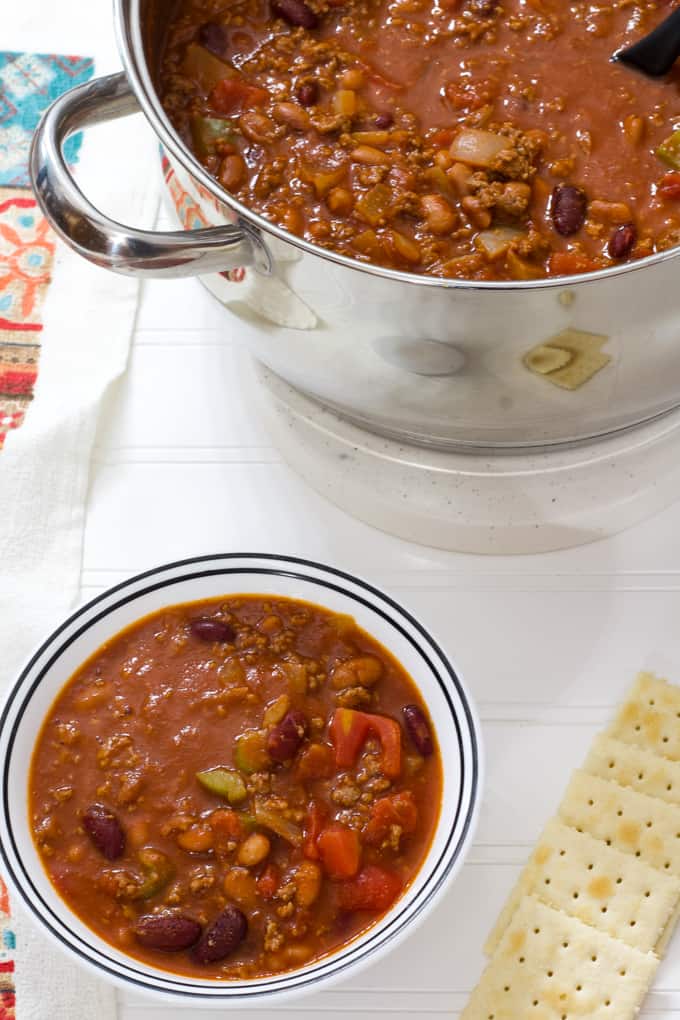 One bowl of chili in the foreground and the pot of chili in the background.