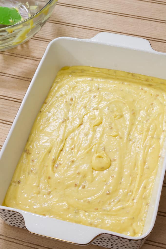 The unbaked cake batter in a white and black stoneware baking pan.