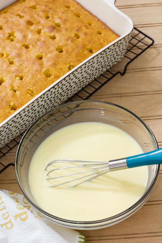 The baked cake in the background and a bowl of pudding in the foreground.