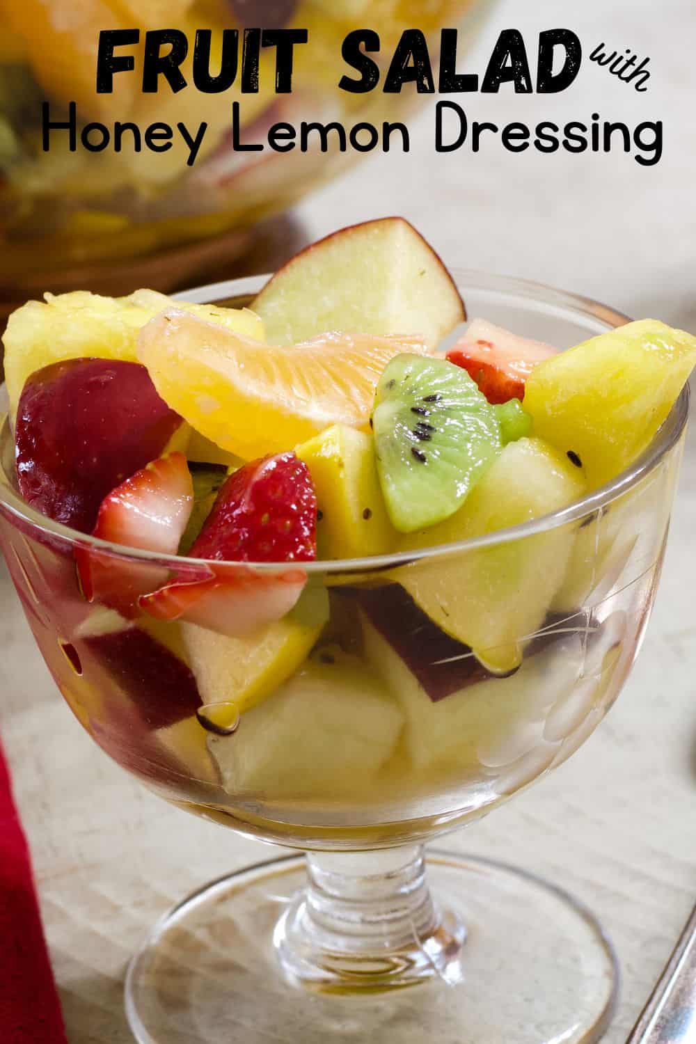 Close up view of a small glass dessert bowl filled with fresh fruit salad.