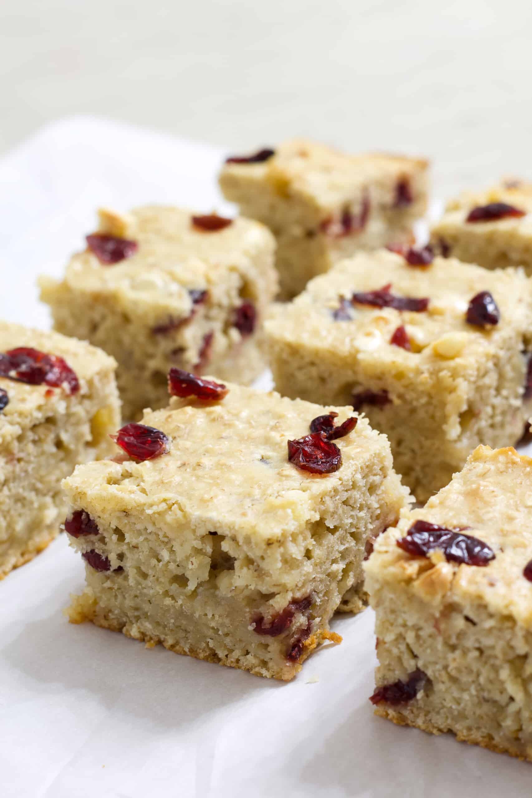 Side view of several oatmeal bars with white chocolate chips and dried cranberries.