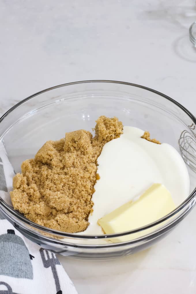 Brown sugar, heavy cream and butter in a glass bowl ready to go into the microwave.