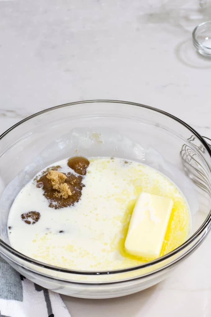 Brown sugar, heavy cream, and butter in a glass bowl after it has been in the microwave.