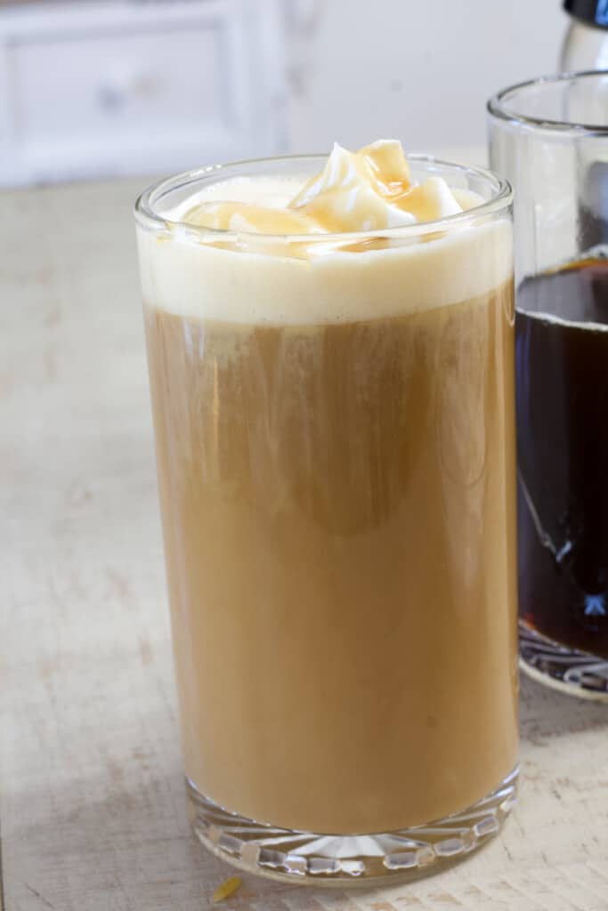 Close up side view of one clear coffee mug full of caramel flavored coffee.