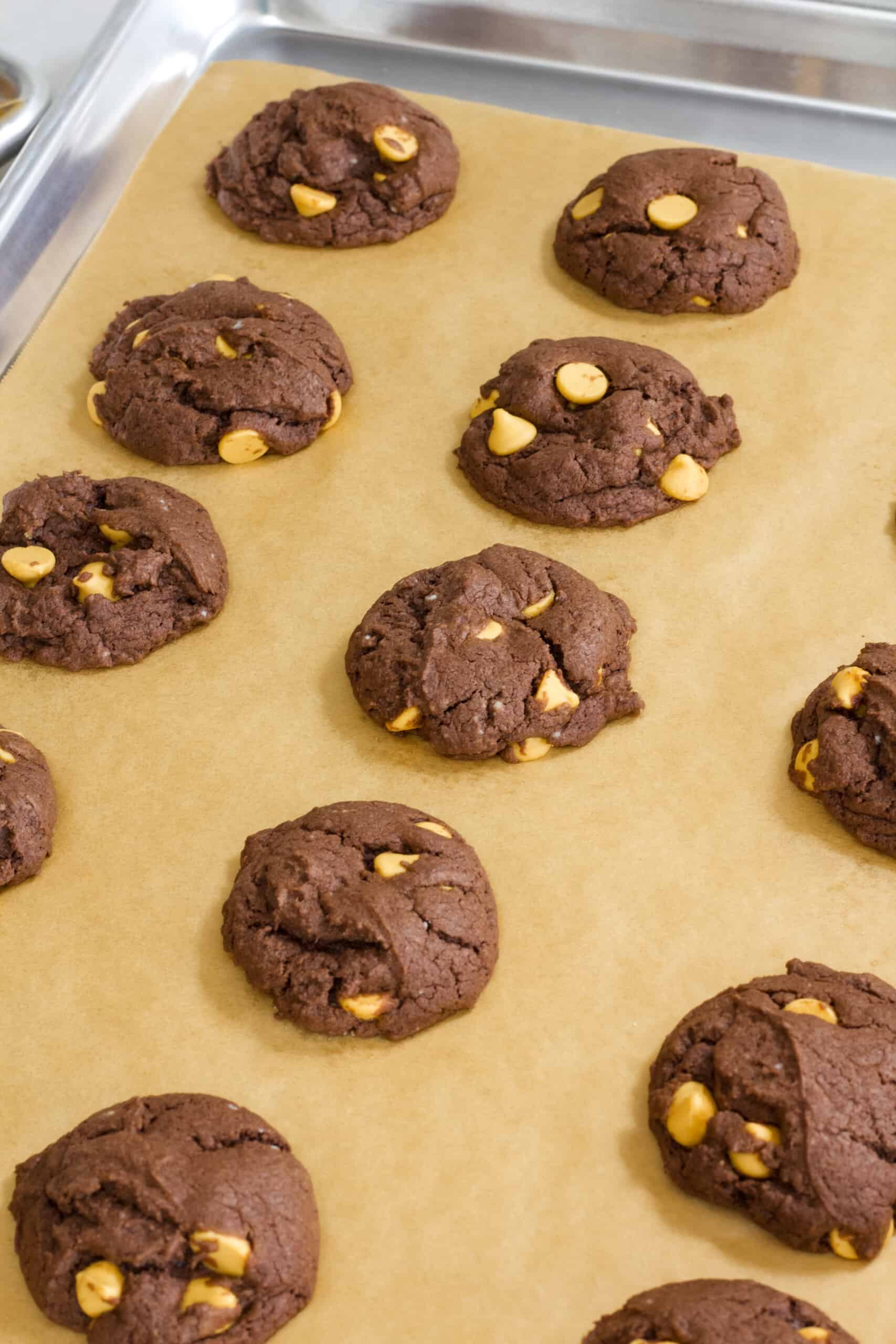 A rimmed baking sheet covered in parchment paper with cookies on it.