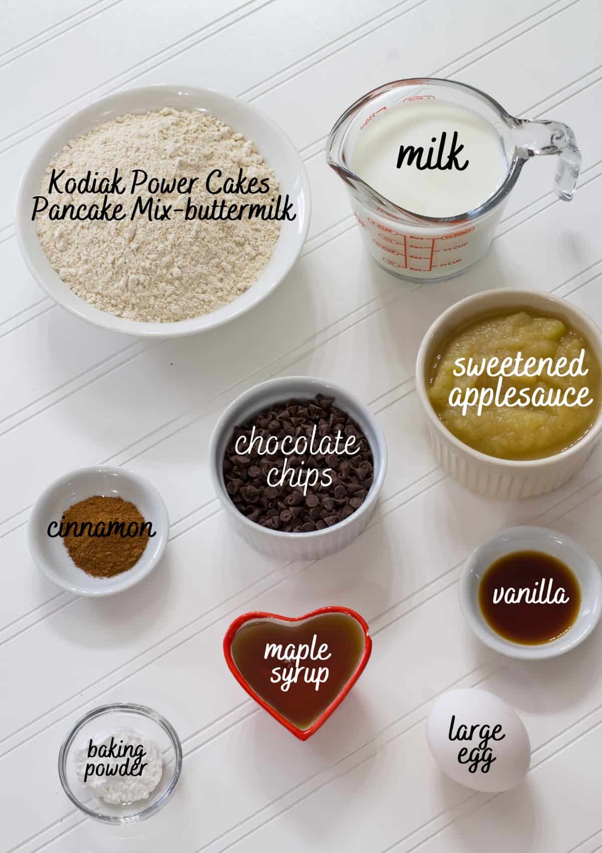 All of the ingredients needed to make kodiak cake muffins with the text on the image to specify what every ingredient is.