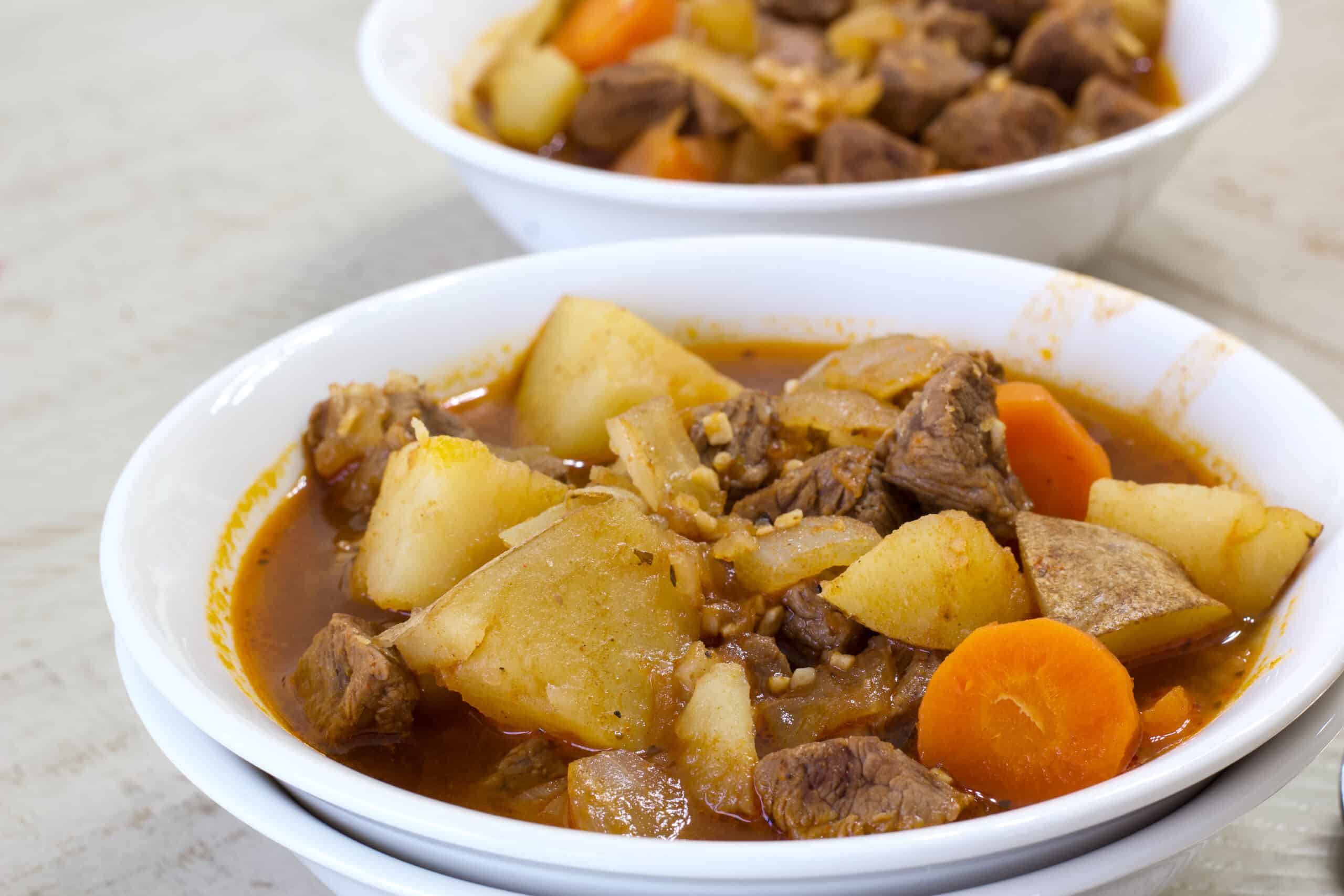 A bowl of goulash soup in the foreground and one in the background.