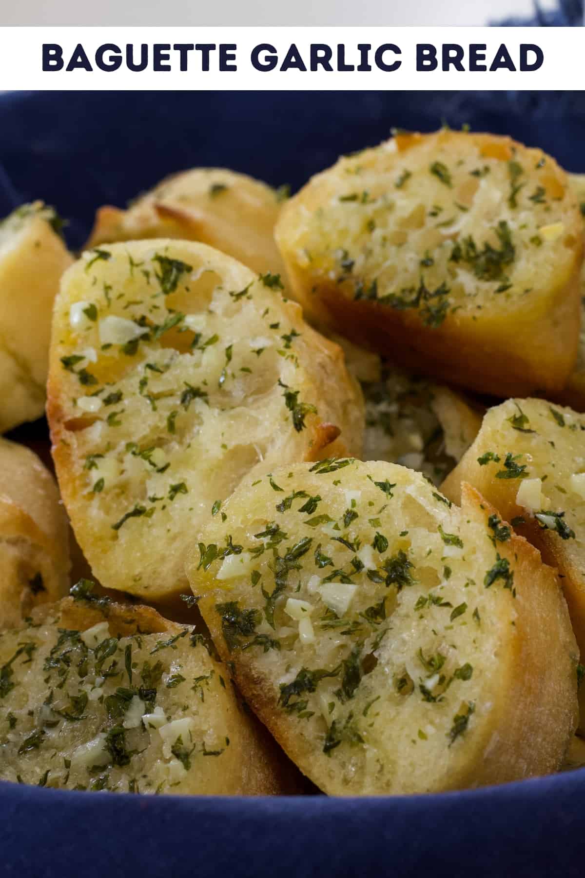 A basket full of baguette garlic bread slices with the recipe title above it so it can be pinned on Pinterest.