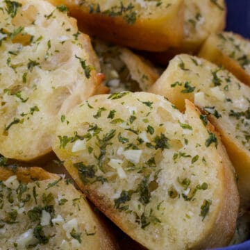 Close up of the sliced garlic bread so you can see the parsley and garlic.