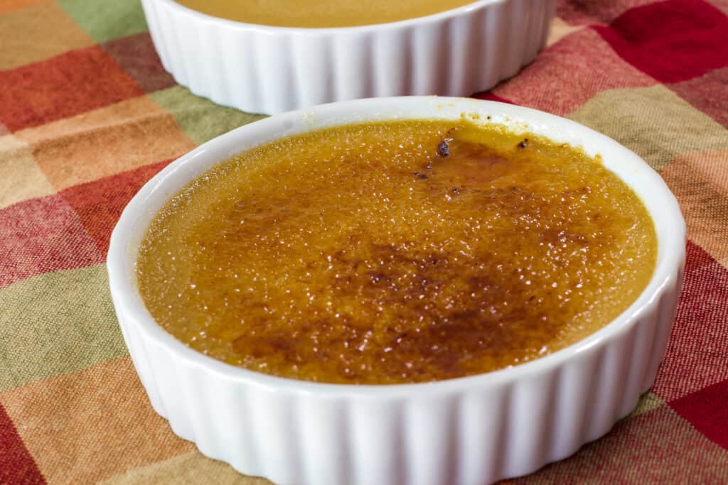 Full ramekin of coffee creme brulee and the sugar on top has been caramelized using a torch.