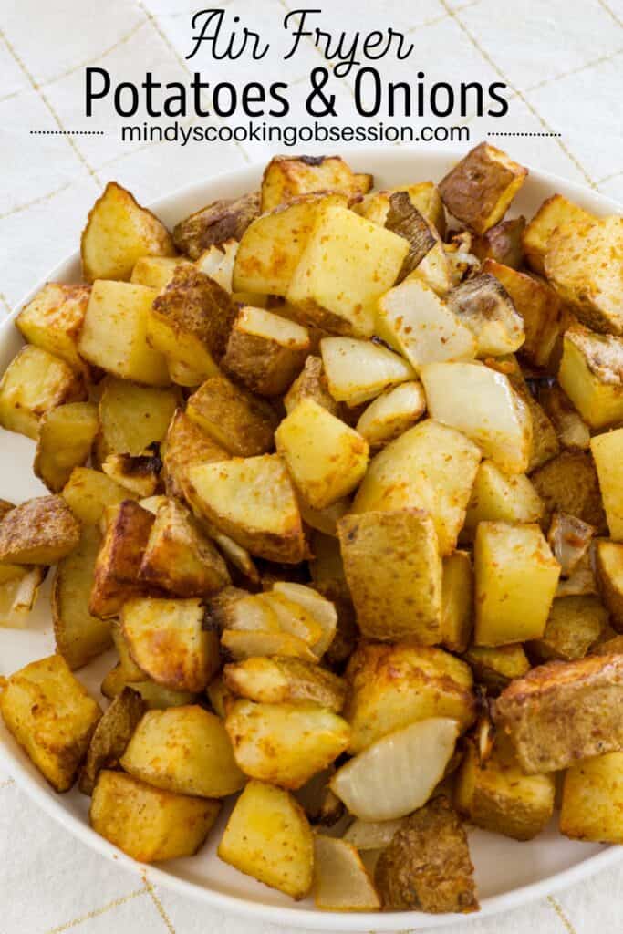A white plate full of air fryer seasoned potatoes and onions with the recipe title above it.