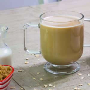 One cup of oat milk coffee in a clear glass coffee mug.