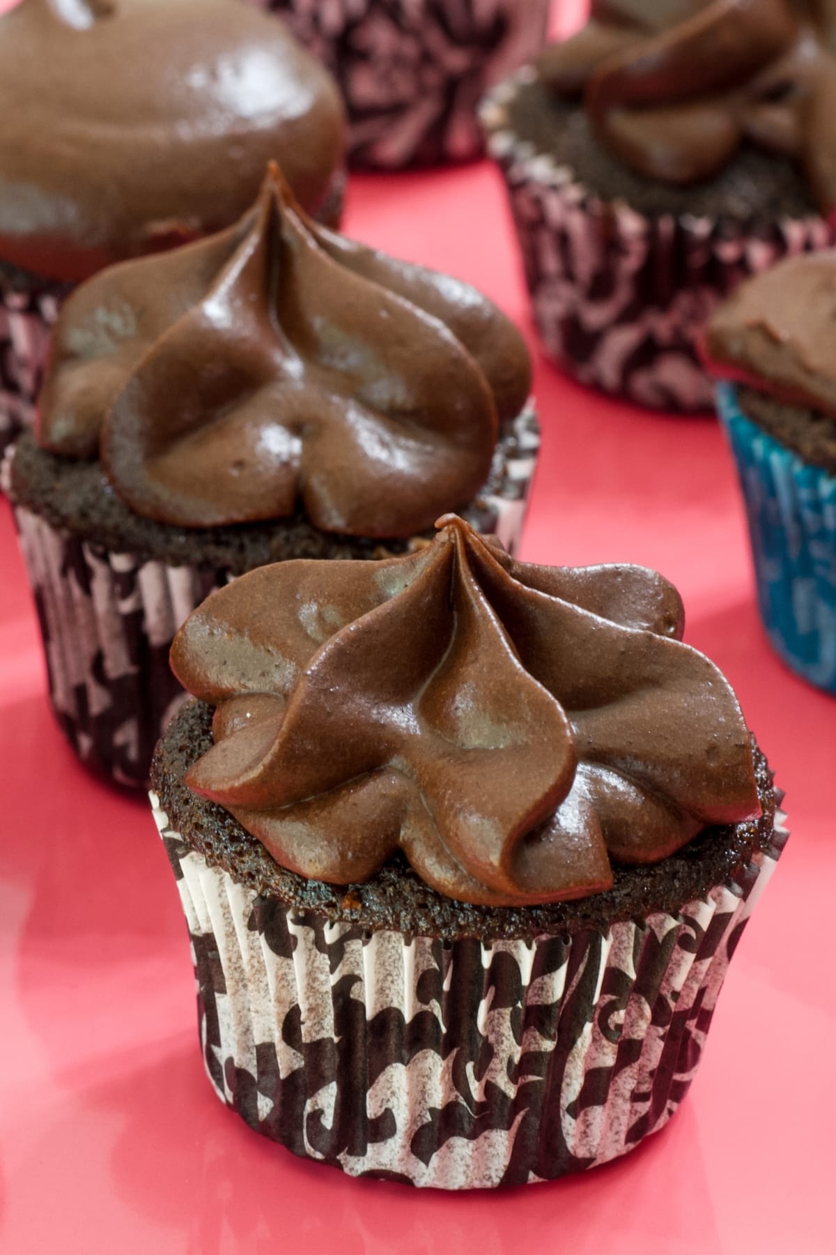 A mini chocolate cupcake with chocolate frosting piped on it.