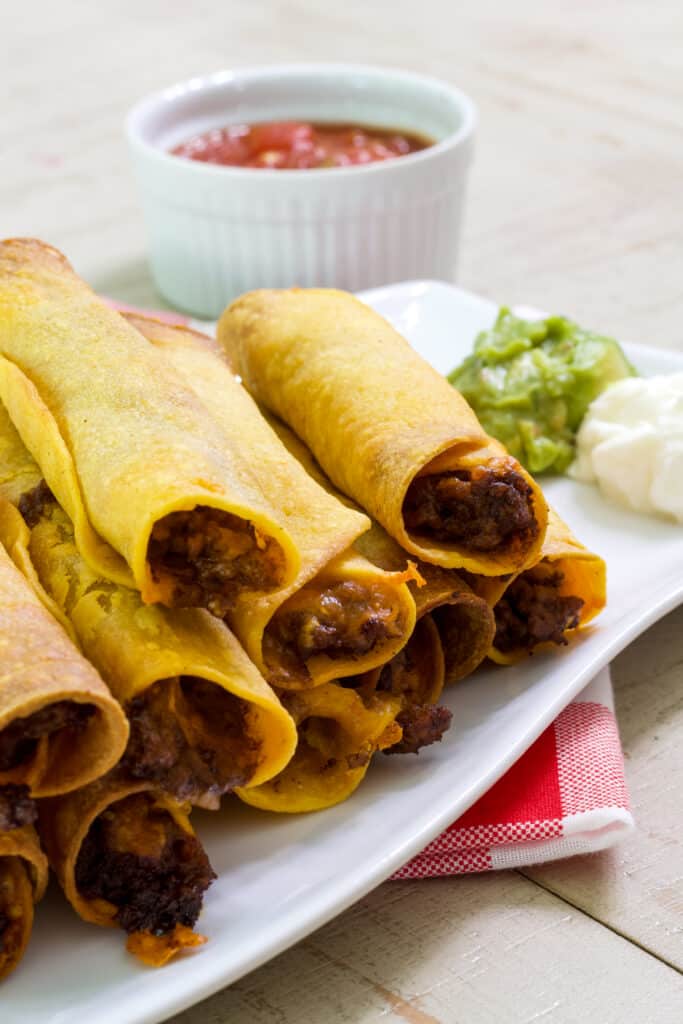 A close up of the open end of the beef taquitos showing the beef and melted cheese inside.