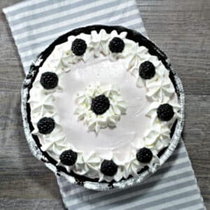 Overhead view of the Easy Blackberry Yogurt No Bake Pie with Cool Whip sitting on a striped tea towel.