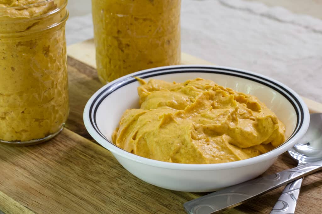 A small white bowl with a black rim that has one serving of Low Calorie Weight Watchers Pumpkin Fluff in it.