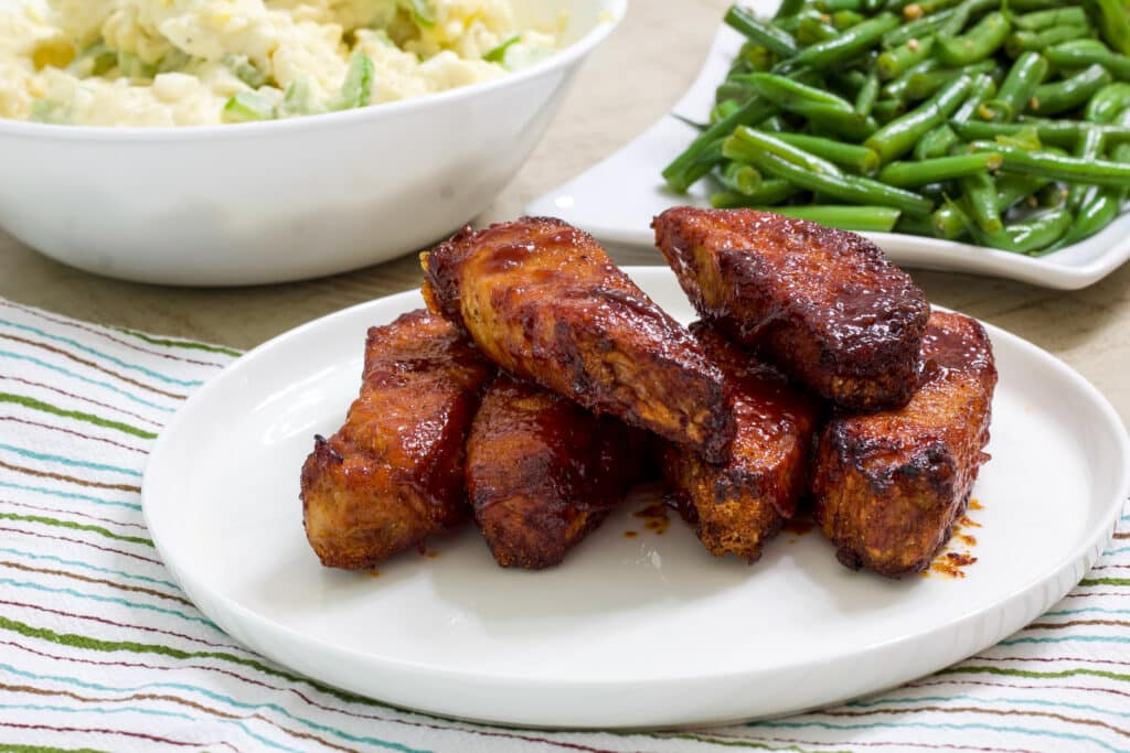 A plate of rib sitting on a green, blue and brown striped tea towel.