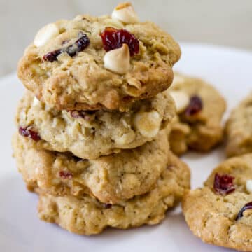 Four Soft Oatmeal White Chocolate Chip Cranberry Cookies stacked on top of each other.