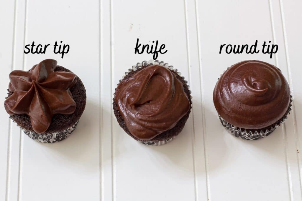 Three mini chocolate cupcakes one frosted with a star tip, one with a knife and one with a round tip.