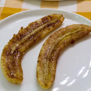 A banana that has been split in half lengthwise and covered with melted butter and cinnamon sugar then air fried.