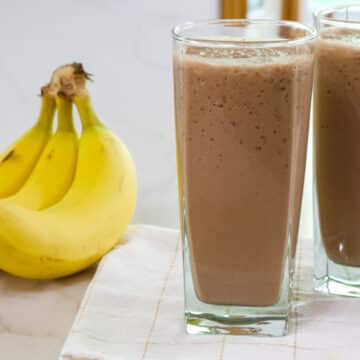 A glass full of Easy & Healthy Chocolate Coffee Smoothie with a bunch of bananas.