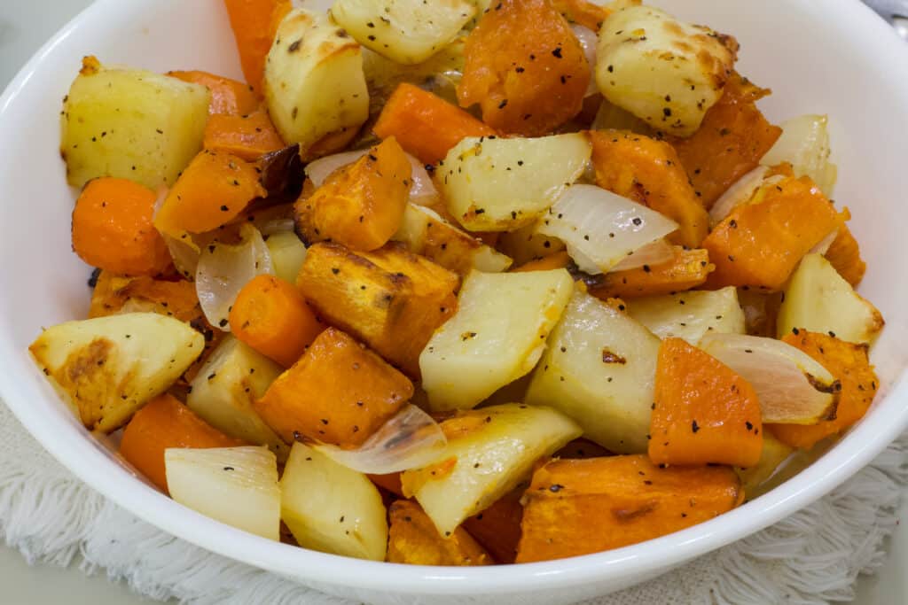 A white bowl with several servings of Easy Oven Roasted Root Vegetables in it.