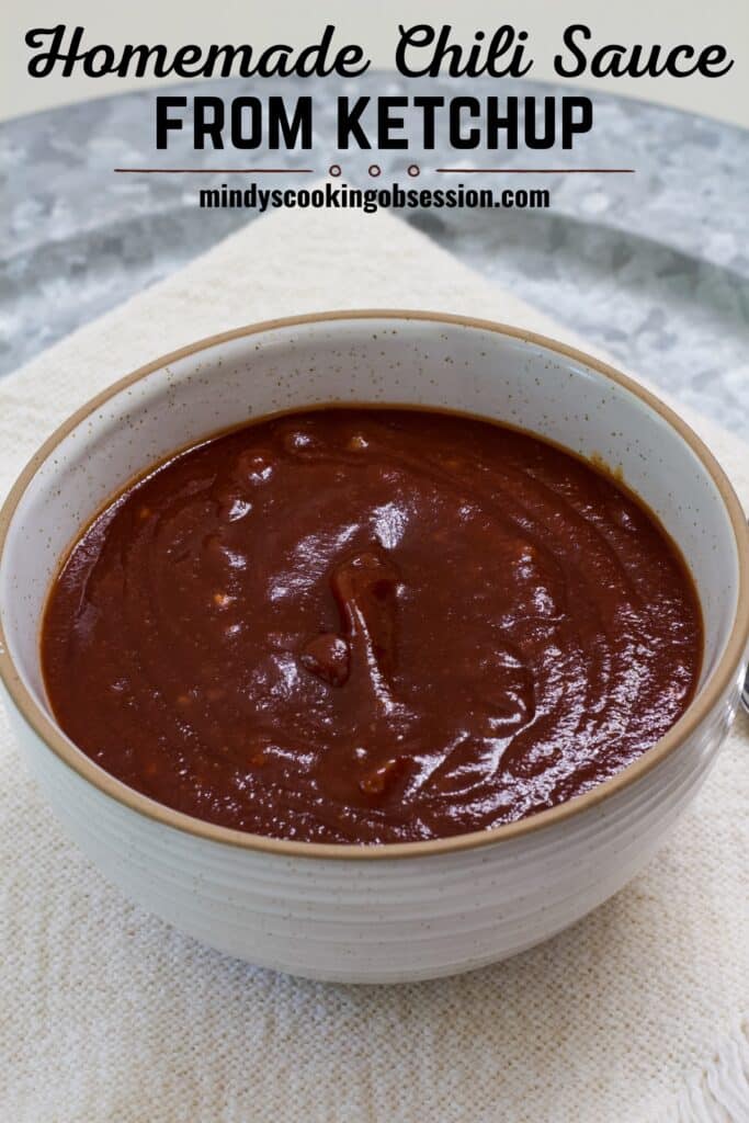 A small cream colored bowl filled with homemade chili sauce made with ketchup and the recipe title in text above it.