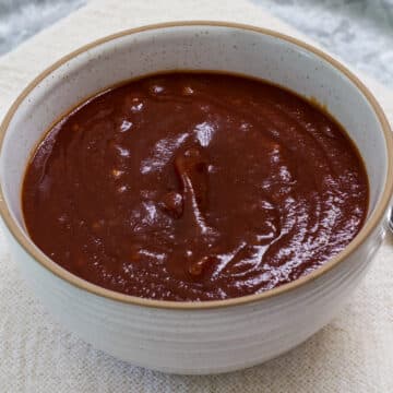 A small cream colored bowl of homemade chili sauce made with ketchup.