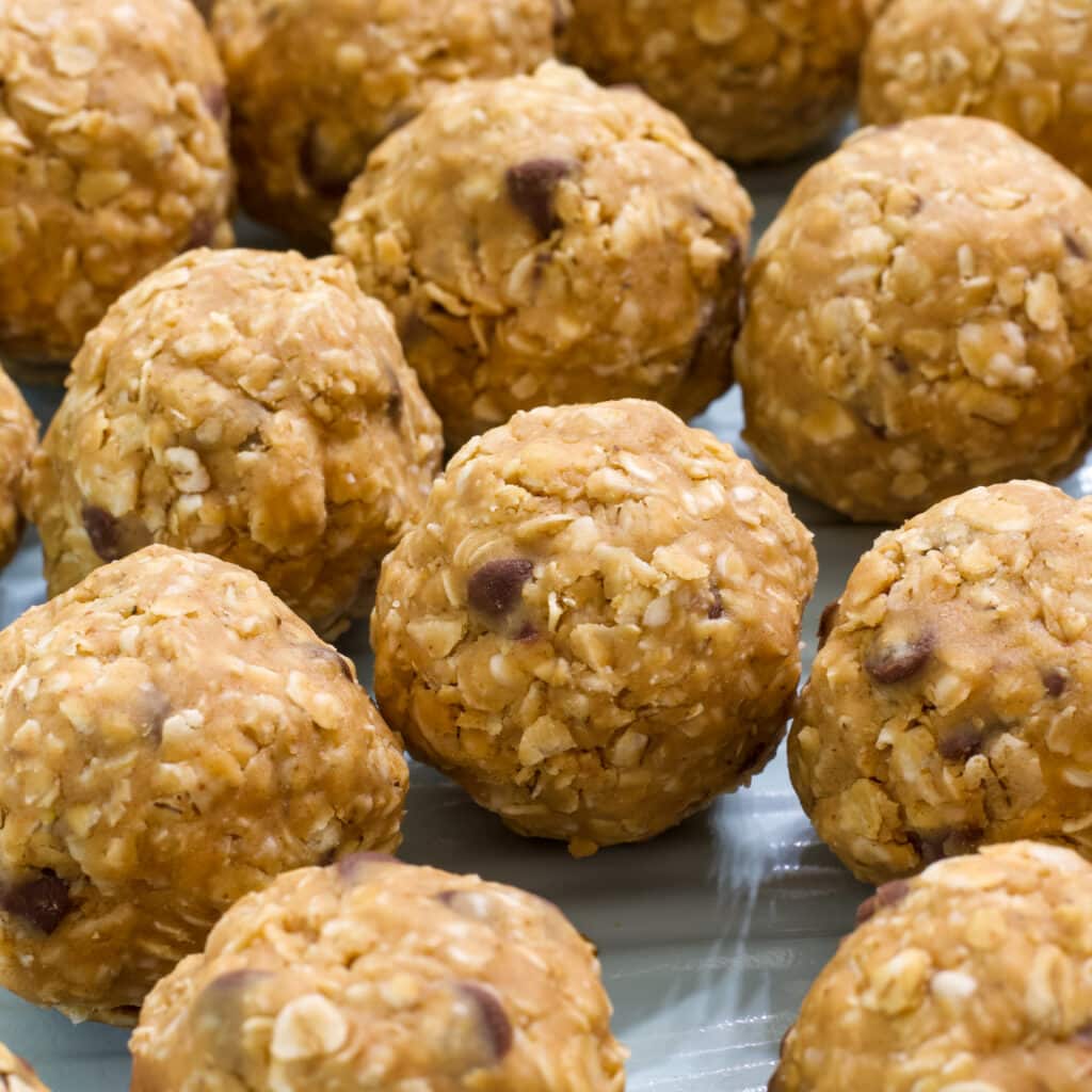 Many 4 Ingredient Protein Rich Peanut Butter Energy Balls on a turquoise sheet pan.