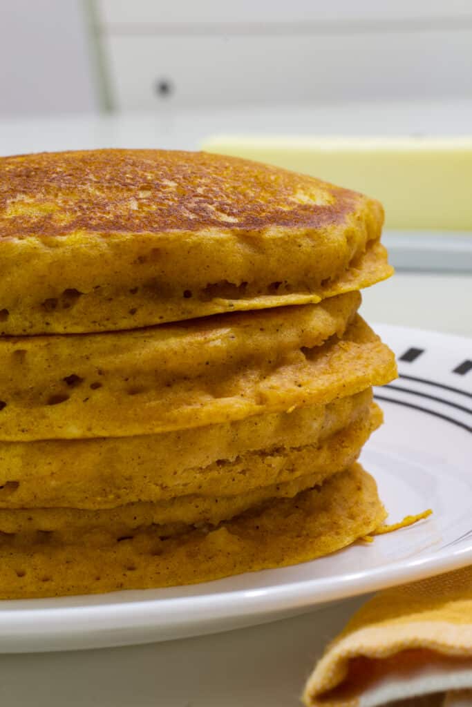 Close up view of the stack of 4 pancakes and only half of the stack is visible.
