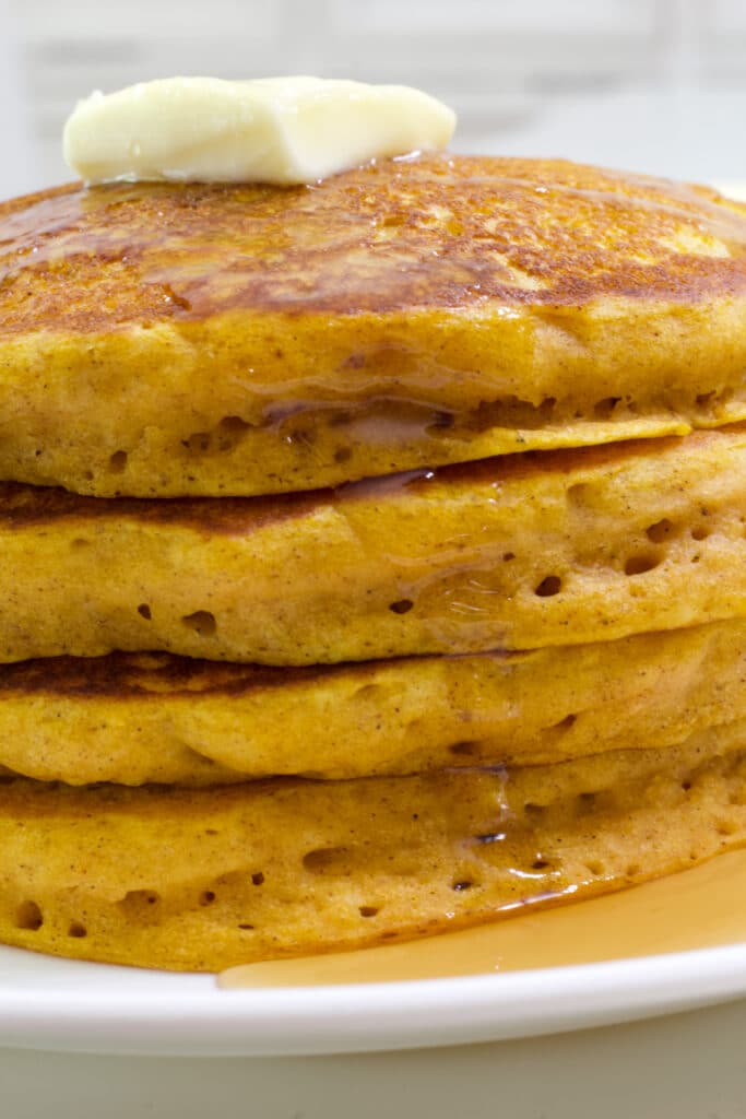 Close up view of a stack of 4 pancakes with just the center visible.