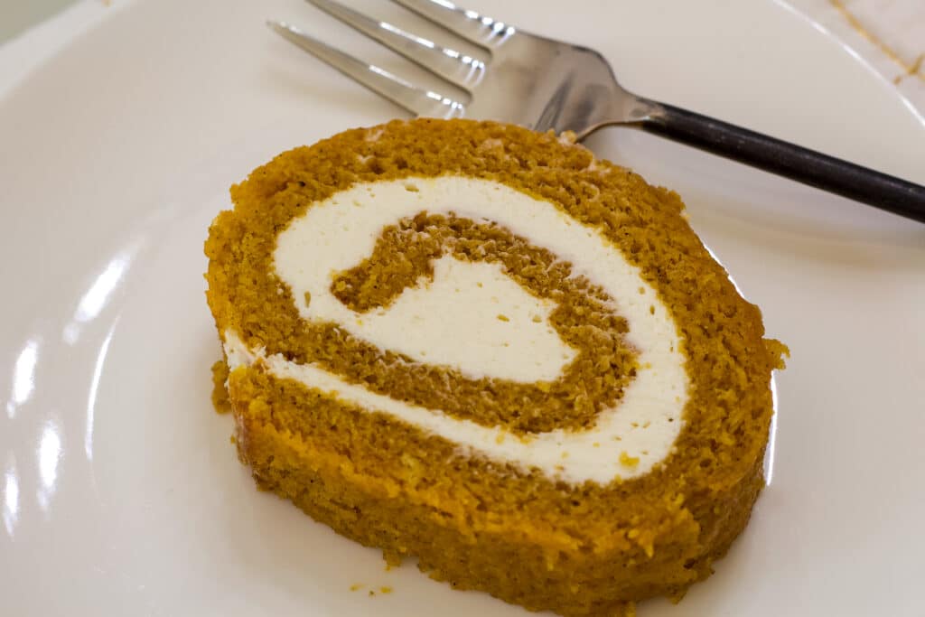 One slice of libby's pumpkin roll on a white plate.