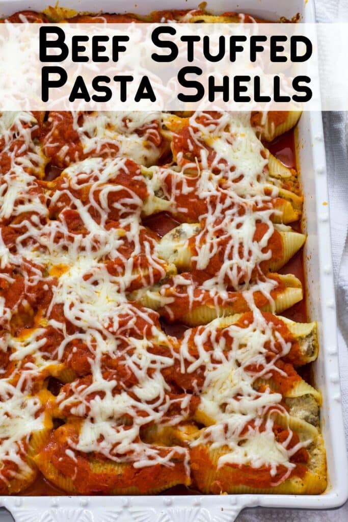 Part of the baking dish of ground beef stuffed shells is in the shot, the recipe title is at the top in text.