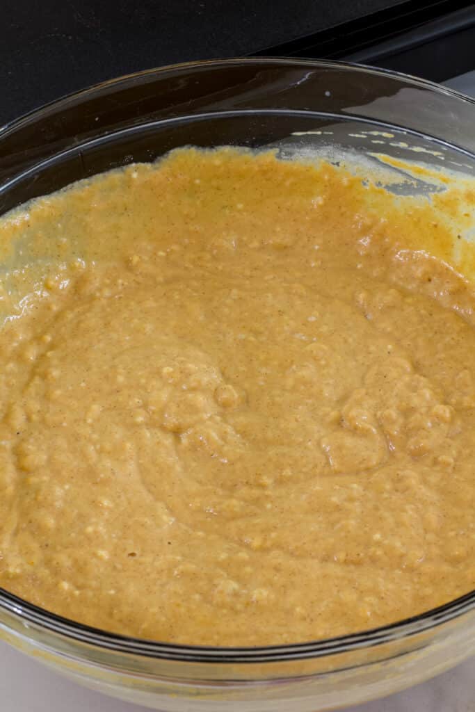 The completed pumpkin pancake batter in a large glass mixing bowl.