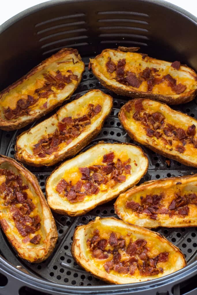 Eight potato skins topped with cheese and bacon after they have been air fried. There is no sour cream or green onions on them yet.