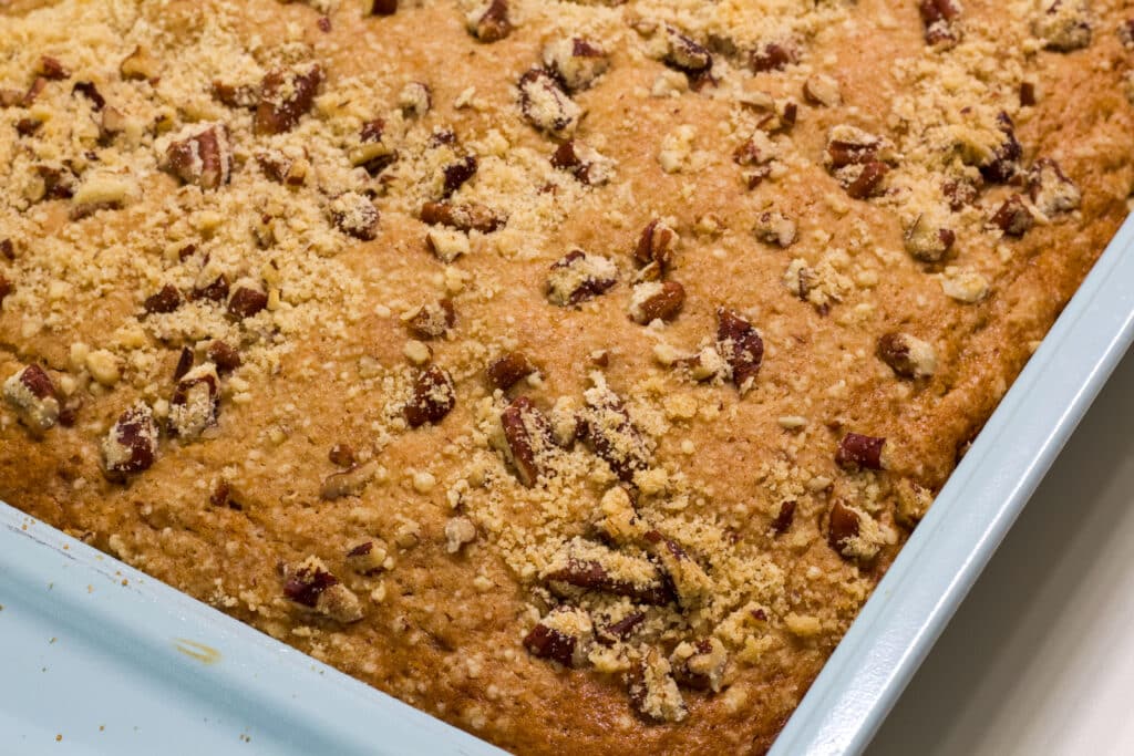 The corner of the cake pan with the whole cake in it before being cut is visible.