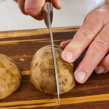 Half of a potato being cut in half.