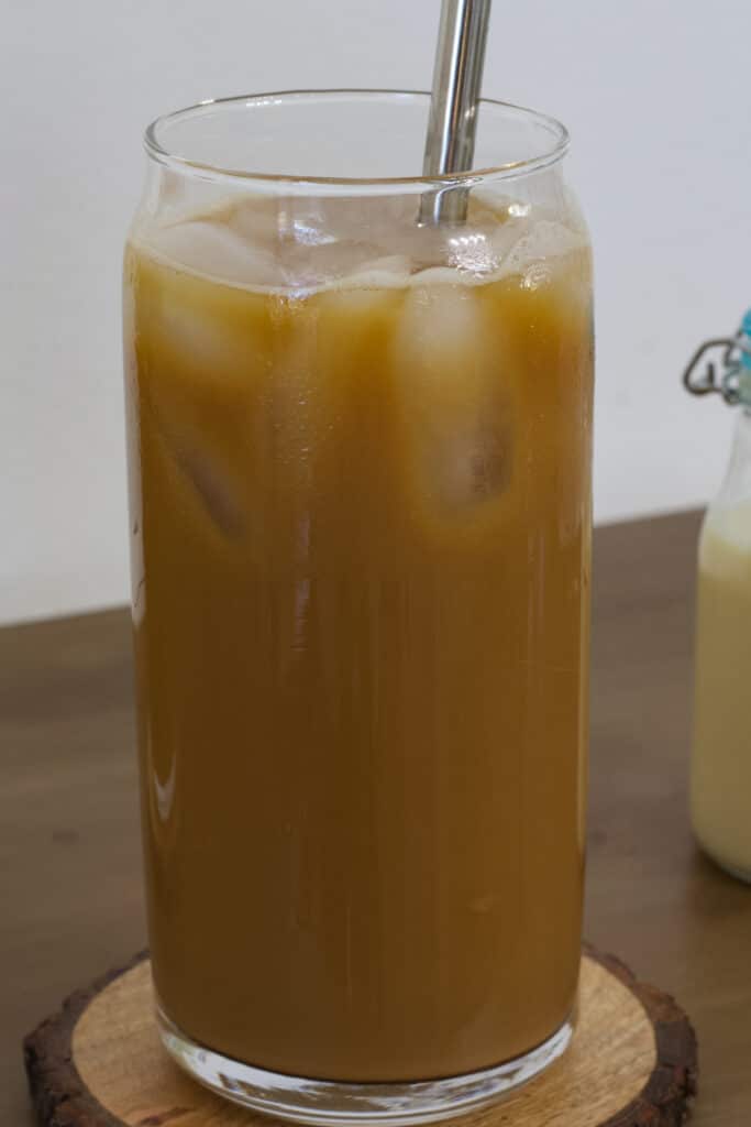 One tall glass of Iced Coffee Recipe with Sweetened Condensed Milk with a metal straw in it.