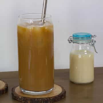 The featured image that has a glass of Iced Coffee Recipe with Sweetened Condensed Milk and a small bottle of milk.