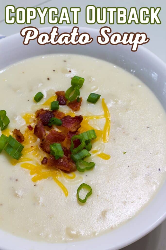 A bowl of Outback Steakhouse Potato Soup topped with bacon bits, shredded cheese, and green onions. The recipe title is at the top in text.