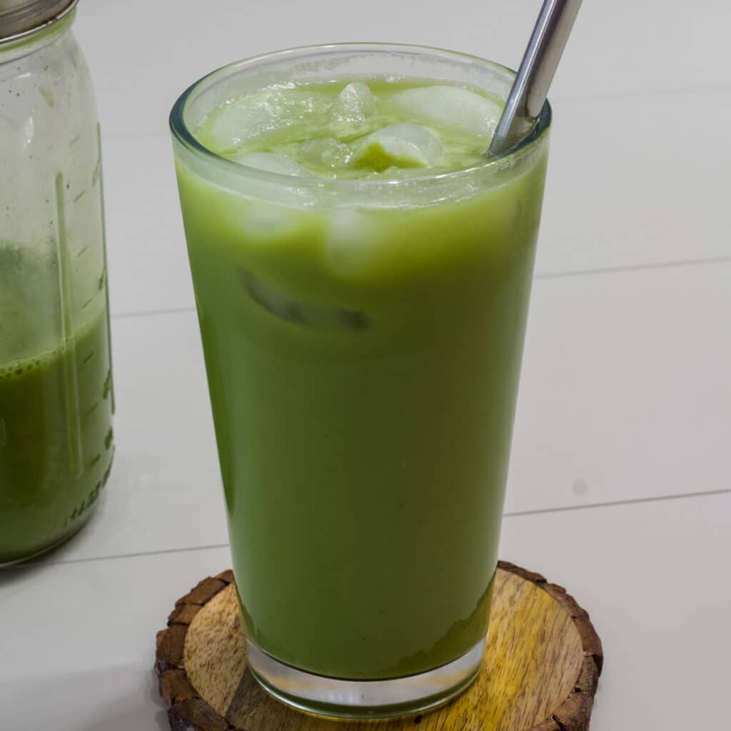 One serving of Copycat Starbucks Iced Pineapple Matcha Drink in a glass with ice and one serving in a mason jar.