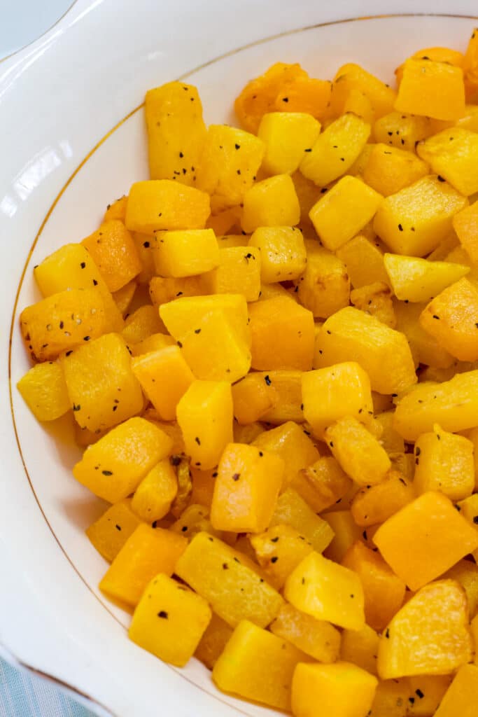 One half of a bowl of roasted butternut squash is in view.