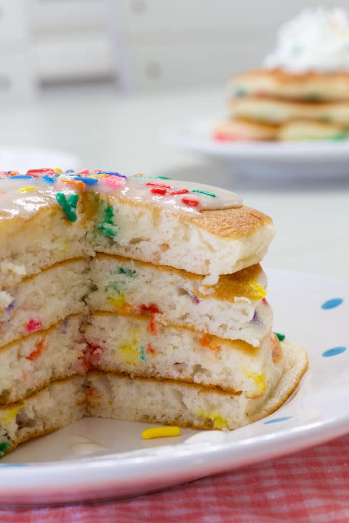 A stack of four fluffy cake mix pancakes with a serving cut out so the inside of the pancakes are visible.