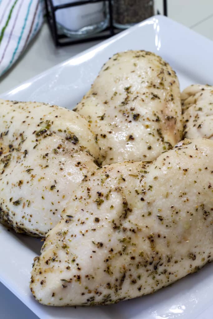Four chicken breasts that have been seasoned and cooked at 350°.