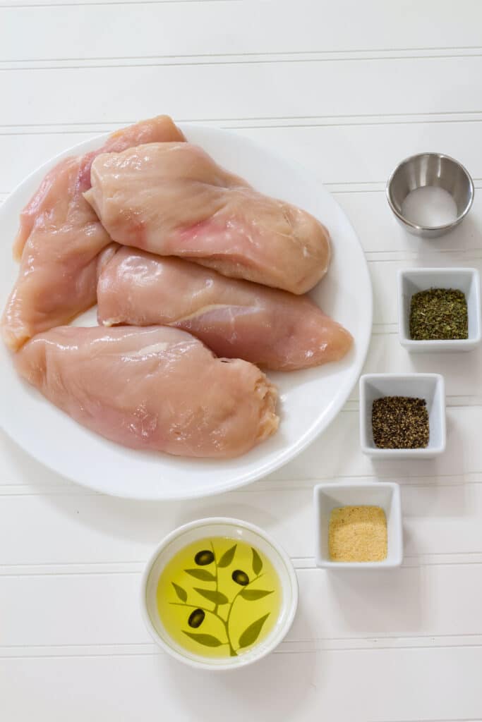 The raw chicken, salt, pepper, garlic powder, Italian seasoning and olive oil needed to make this recipe.