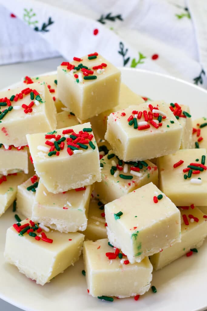 A plate full of several pieces of Sugar Cookie Christmas Fudge.
